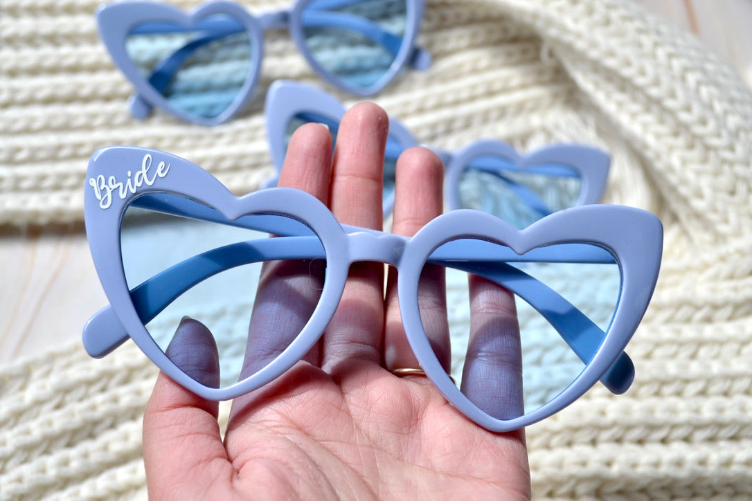 Close-up of dusty blue heart sunglasses for 30A and coastal wedding celebrations