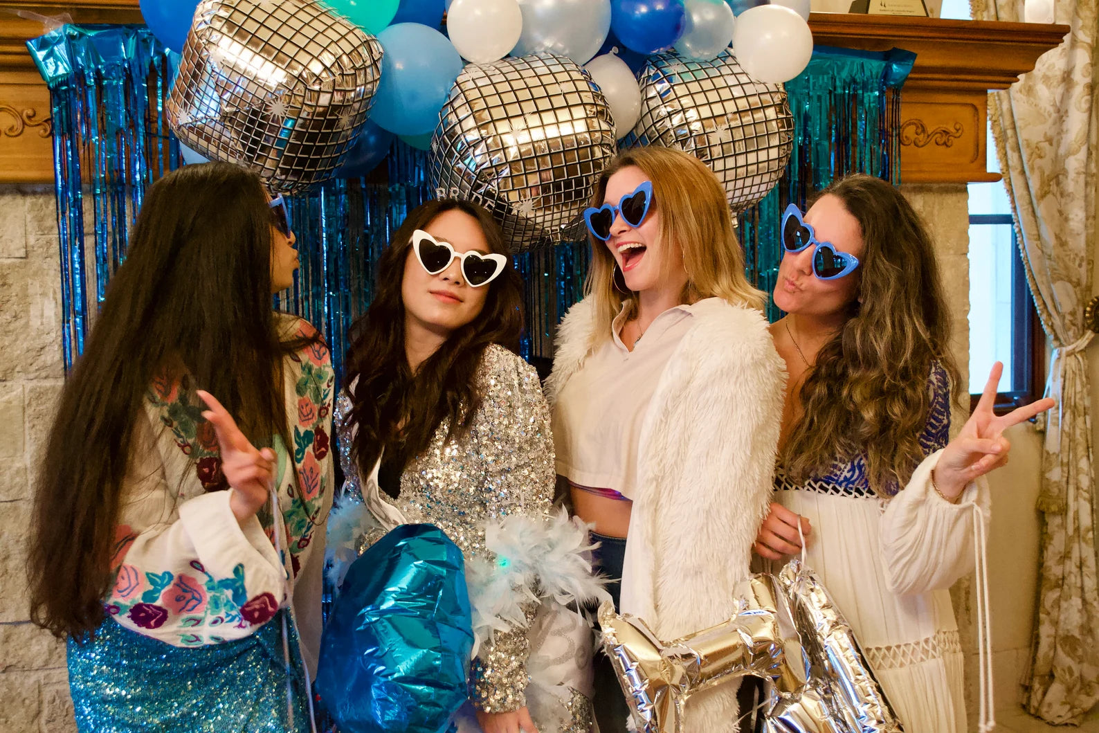 Group of bridesmaids and bride wearing matching heart-shaped sunglasses at a bachelorette party